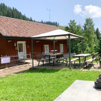 Aussenansicht mit Sitzplatz im Sommer.
