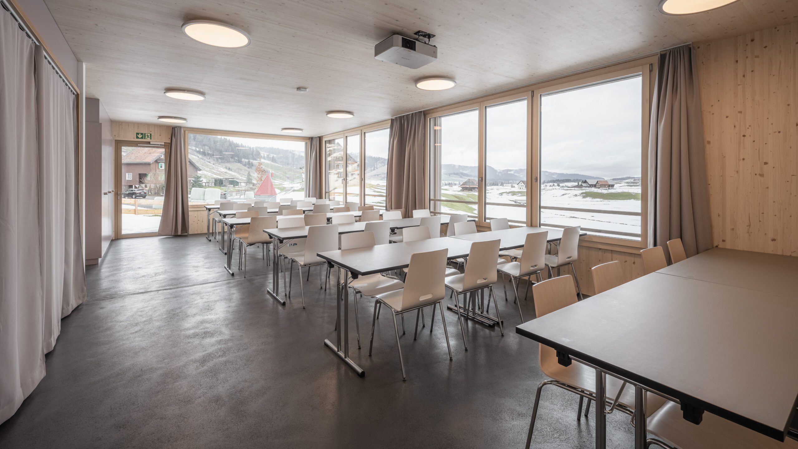 Der helle, moderne Esssaal mit grossen Fenstern.