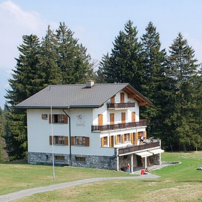 Das Skihaus von aussen. Dreistöckiger Bau mit Balkon.